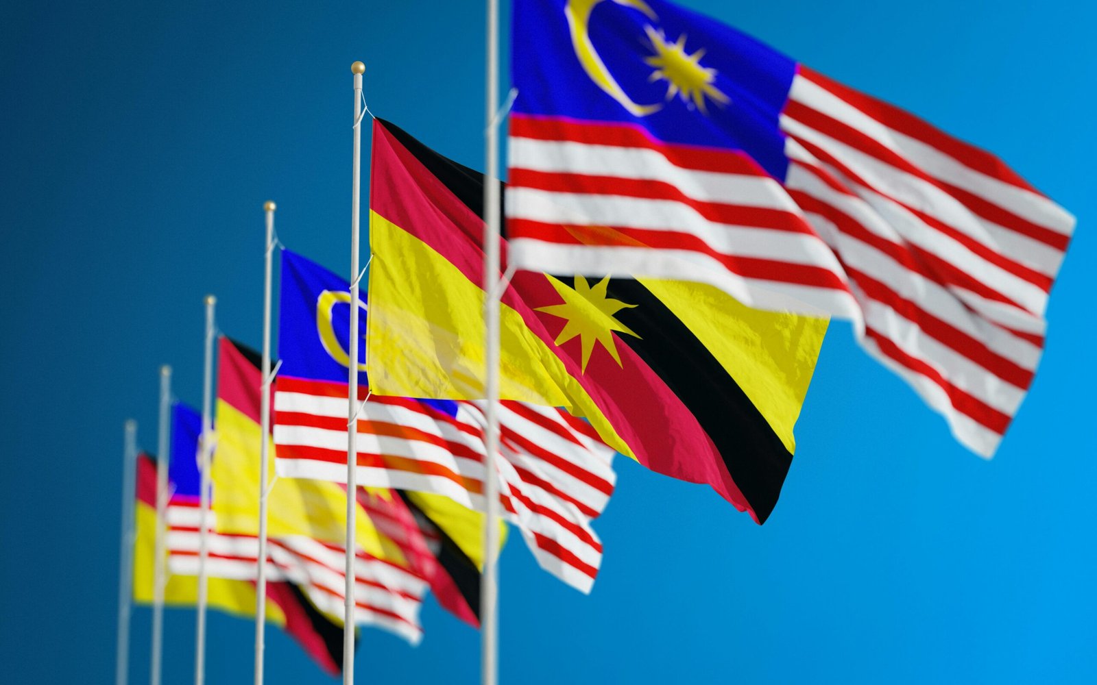 pexels-photo-5472462-5472462 Vibrant display of Malaysian and Sarawak flags symbolizing unity and patriotism against a clear blue sky.