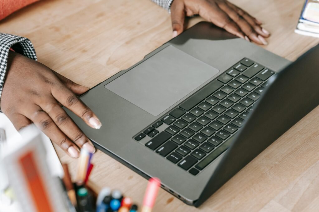 Close-up of woman's hands on laptop keyboard in a professional office environment, perfect for business or tech themes.
